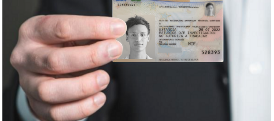 A hand holding a Spanish "Permiso de Residencia" (TIE) card for study and research purposes.